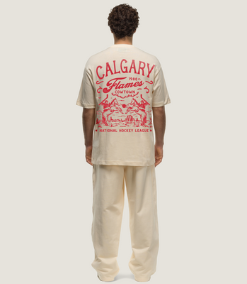 Basico Branco Calgary Flames oversized tee with bold red Cowtown back graphic, styled with cream pants.