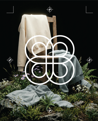 Basico Branco organic cotton sweatshirts styled on a wooden chair in a lush outdoor setting, showcasing premium wholesale apparel.