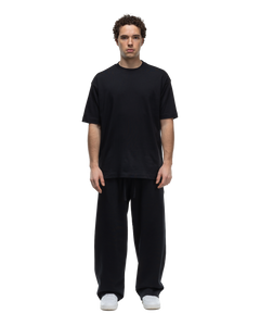 Basico Branco Oversized Crewneck T-Shirt in black paired with Relaxed Fit Pants, front view on model.