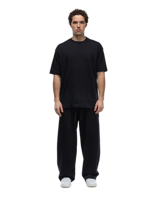 Basico Branco Oversized Crewneck T-Shirt in black paired with Relaxed Fit Pants, front view on model.