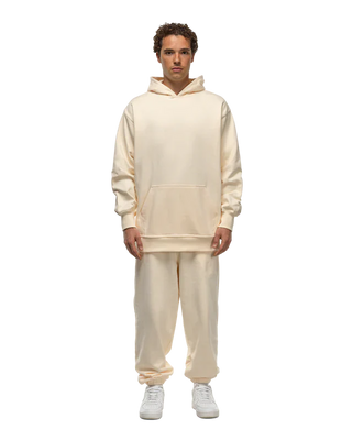 A model wearing a Basico Branco oversized hoodie with kangaroo pockets and cuffed sweatpants. 
